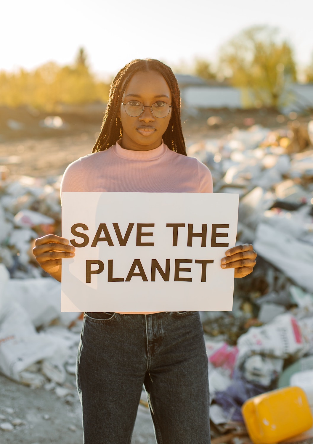 Lady holding up a sign that says save the planet. There is no planet B