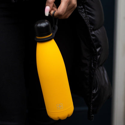 Lady with manicured nails holds a personalised yellow water bottle with a black lid.