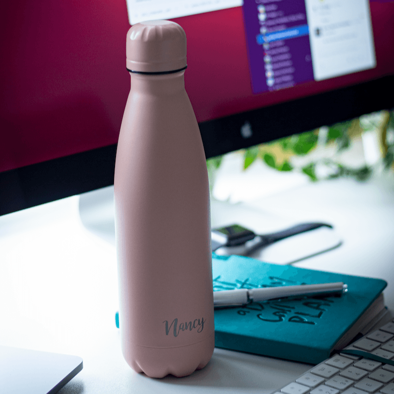 Engraved Stainless steel bottle in Sienna Rose Colour with Note Book And Computer in the Back.