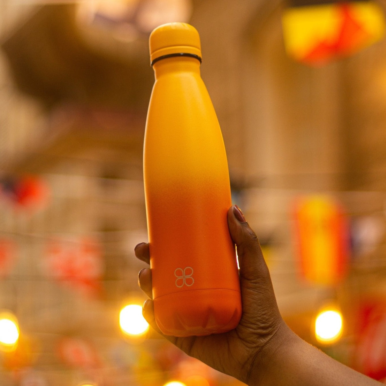 Hand raising up the Sunrise Yellow/Orange Water Bottle 