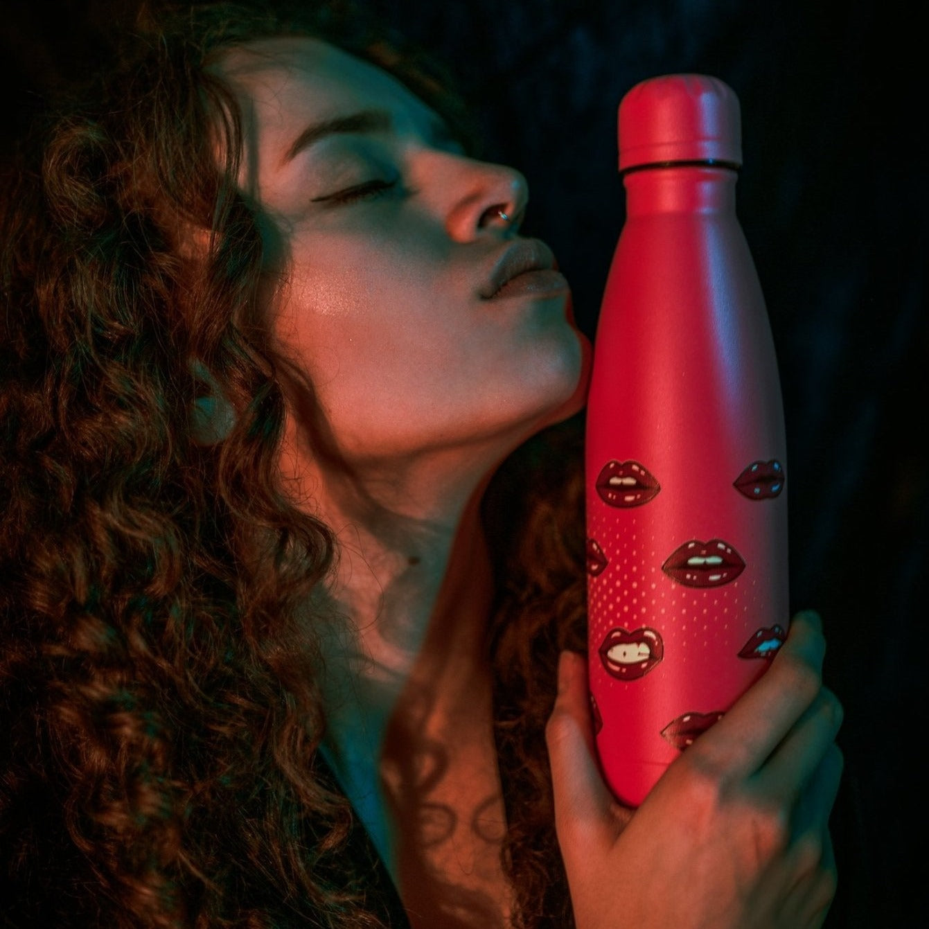 Lady holds up XOXO Pink Water Bottle with lip art